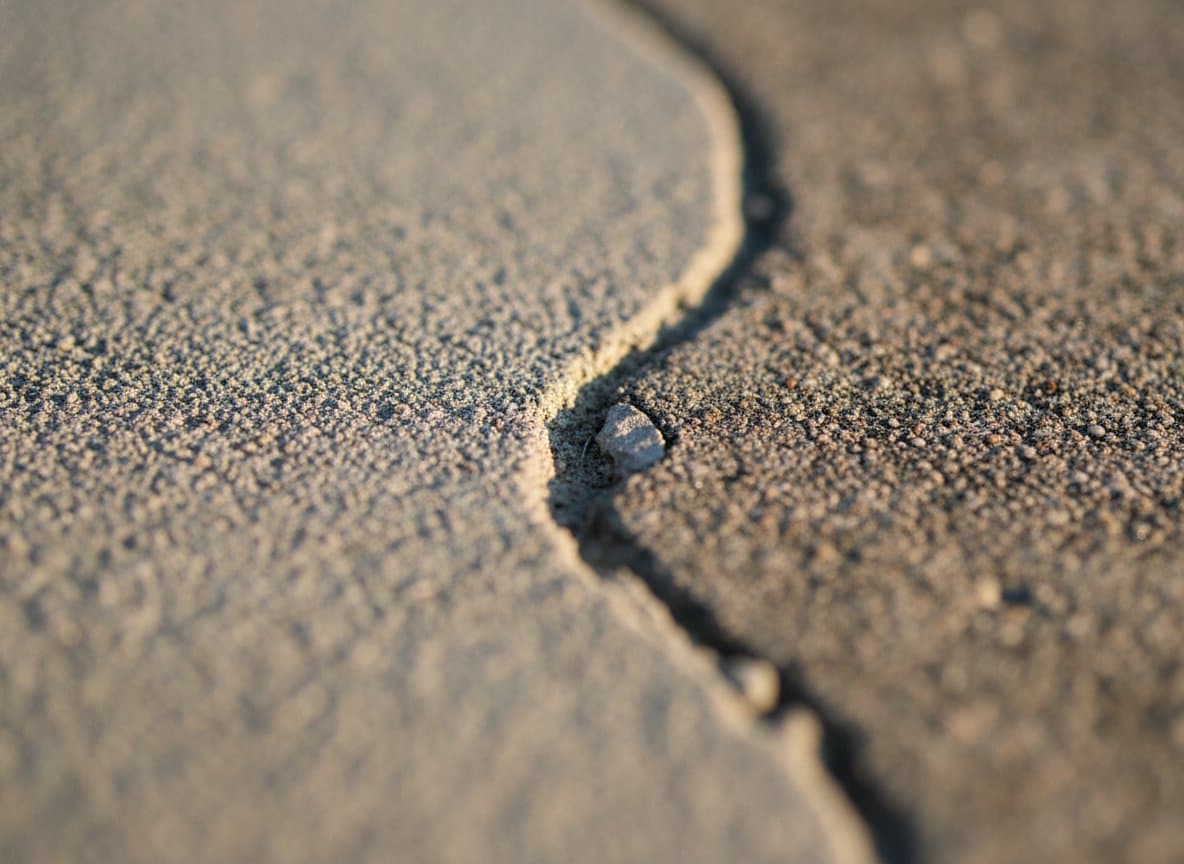 Macro of a fine crack across a concrete slab.